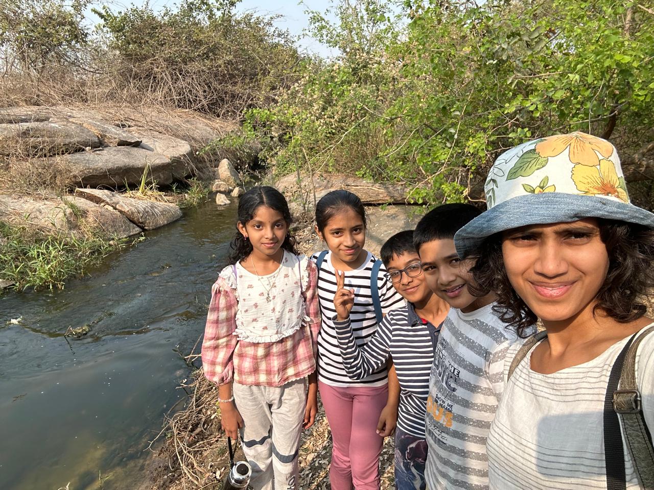 Likhitha with kids by a stream — kids therapy