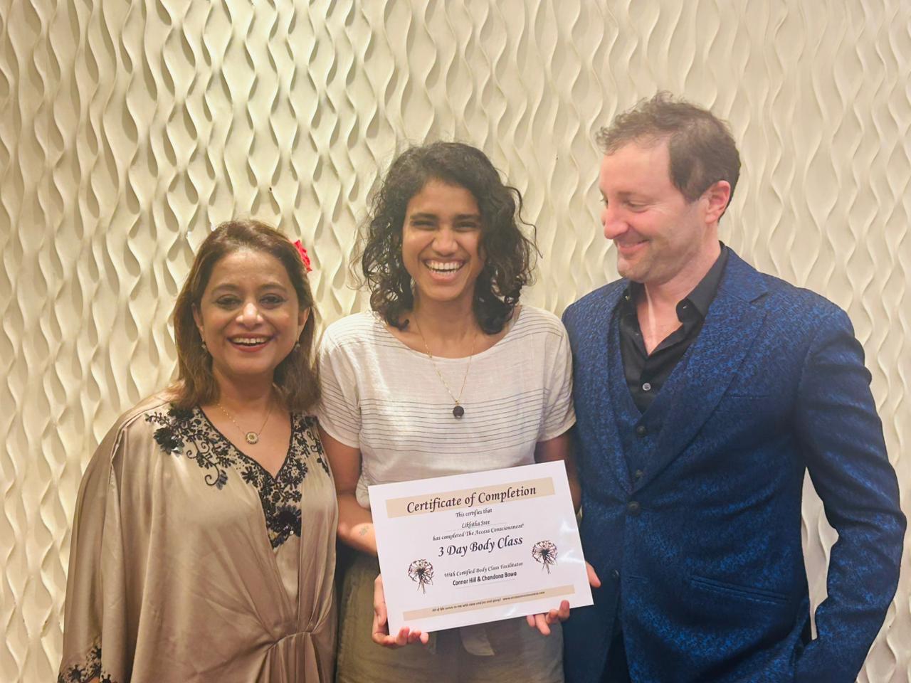 Likhitha Sree holding her Access Consciousness 3 Day Body Class certificate with her certifying facilitators