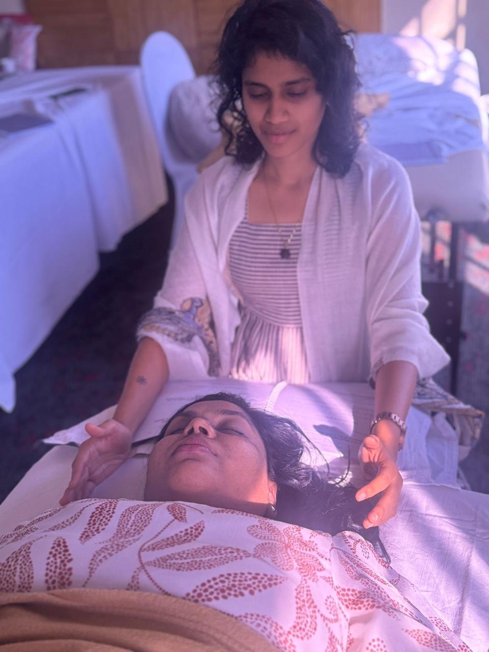 Likhitha performing a hands-on Access Bars session on the beach